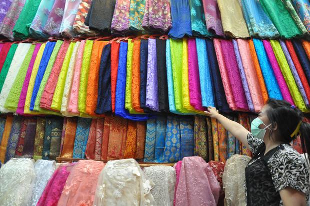 Seorang pedagang menata kain tekstil dagangannya di Pasar Ikan Medan, Sumatera Utara, Rabu (5/2/2020). Pelaku usaha industri tekstil pesimistis ekspor akan mampu tumbuh 10%.