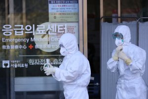 Petugas kesehatan Korea Selatan melintas di depan pusat deteksi virus corona