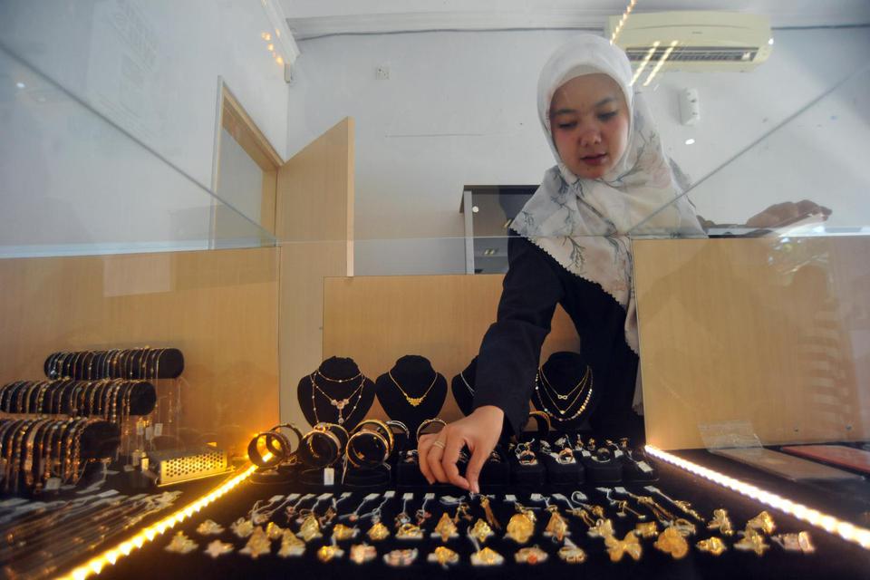 Petugas menunjukkan emas perhiasan, di galeri 24 penjualan Logam Mulia, di Padang, Sumatera Barat, Jumat (21/2/2020). Harga emas dari PT Antam terpantau di laman Logam Mulia pada Jumat (21/2), kembali naik dari Rp788 ribu per gram menjadi Rp793 ribu per g