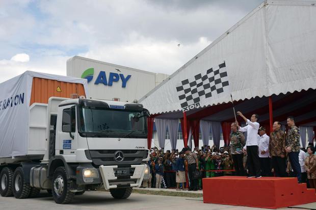 Presiden Joko Widodo mengibarkan bendera saat melepas keberangkatan truk kontainer berisi serat rayon untuk diekspor ke Turki sebanyak 10.190 ton, di pabrik Asia Pacific Rayon (APR), Kabupaten Pelalawan, Riau, Jumat (21/2/2020). APR memproduksi serat rayo