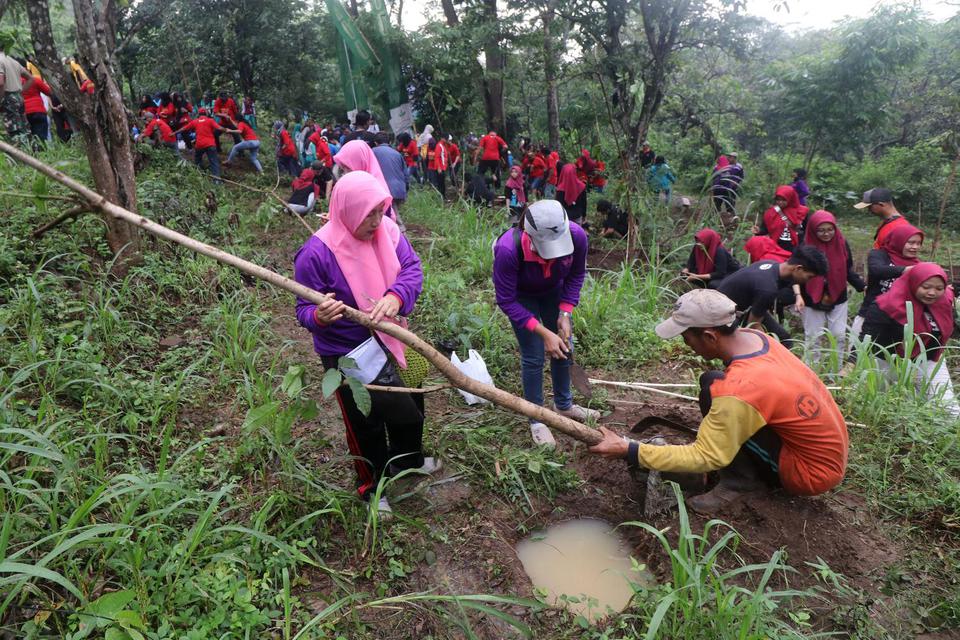 Warga dari sejumlah komunitas menanam pohon di gunung Klotok, Kelurahan Pojok, Kota Kediri, Jawa Timur, Sabtu (22/2/2020). Penanaman seribu bibit pohon berbagai jenis tersebut untuk melestarikan sumber air di wilayah sekitar. Reboisasi adalah proses penan