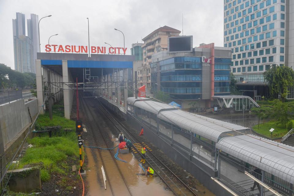 Sejumlah petugas menyedot air dengan pompa yang merendam bantalan rel di Stasiun BNI City, Jakarta, Selasa (25/2/2020). Akibat intensitas hujan yang tinggi sejak Senin (24/2/2020) dini hari, sejumlah daerah di Jakarta terendam banjir.