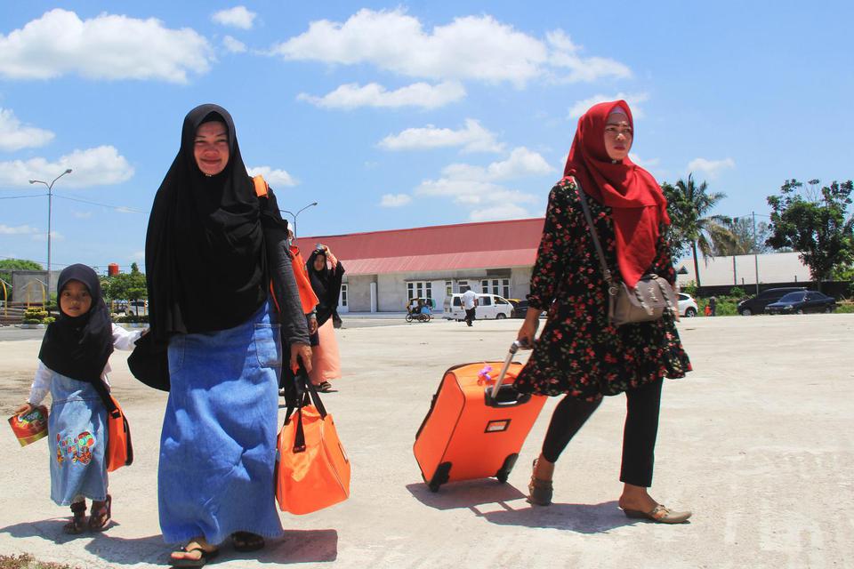 Sejumlah calon jamaah umrah yang batal berangkat ke Jeddah lewat Malaysia berjalan menuju halaman parkir kendaraan di Pelabuhan Internasional PT Pelindo I Dumai di Dumai, Riau, Jumat (28/2/2020).