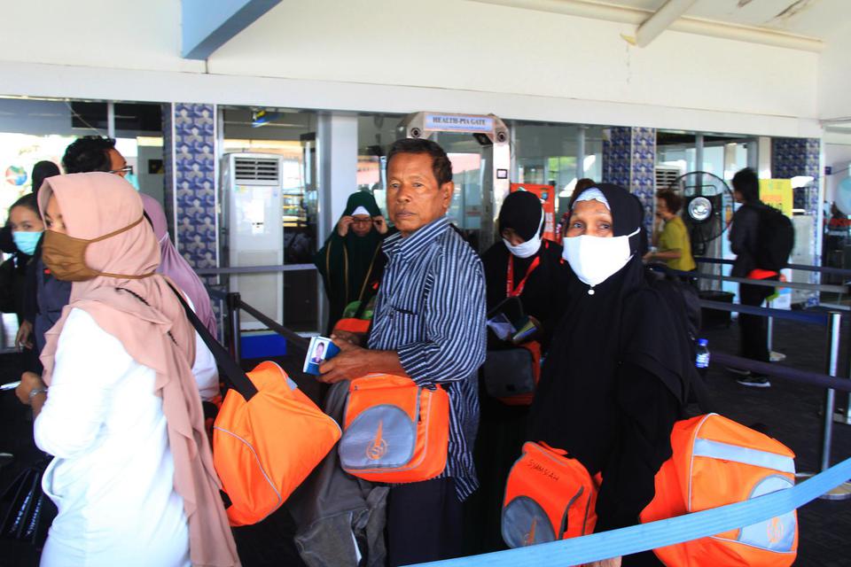 Sejumlah calon jamaah umrah yang batal berangkat ke Jeddah lewat Malaysia tiba di Terminal Kedatangan Penumpang Pelabuhan Internasional PT Pelindo I Dumai di Dumai, Riau, Jumat (28/2/2020).