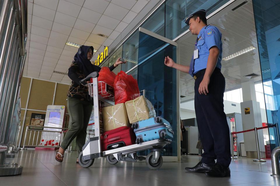 Petugas memeriksa tiket calon penumpang di pintu keberangkatan di Bandara Depati Amir, Kepulauan Bangka Belitung, Senin (2/3/2020). Dalam upaya mendongkrak pariwisata, Pemerintah memberikan diskon tiket pesawat hingga 50 persen untuk 10 wilayah destinasi