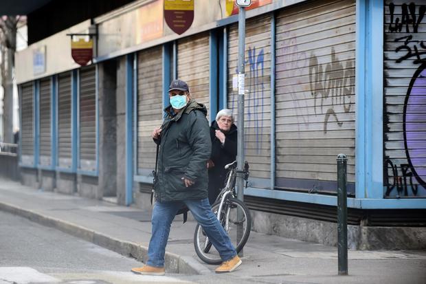 Massimo Pinca Seorang pria dengan masker pelindung berjalan di pasar Madama Cristina, yang sepi setelah pemerintah Italia melaksanakan penutupan daerah besar di utara Italia, di Turin, Italia, Senin (9/3/2020).