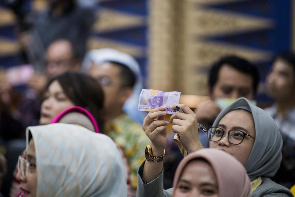 Sejumlah nasabah meraba uang rupiah saat sosialisasi Pekan Quick Response Code Indonesia Standard (QRIS) Nasional 2020 dan sosialisasi mata uang rupiah di Bandung, Jawa Barat, Kamis (12/3/2020). Sosialisasi tersebut dilakukan guna mendorong upaya penetras