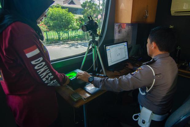 Petugas melayani warga yang memperpanjang Surat Izin Mengemudi di layanan SIM Keliling di Palu, Sulawesi Tengah, Selasa (17/3/2020). Meskipun ada anjuran dari pemerintah setempat untuk membatasi pergerakan warga untuk mencegah makin masifnya penyebaran CO