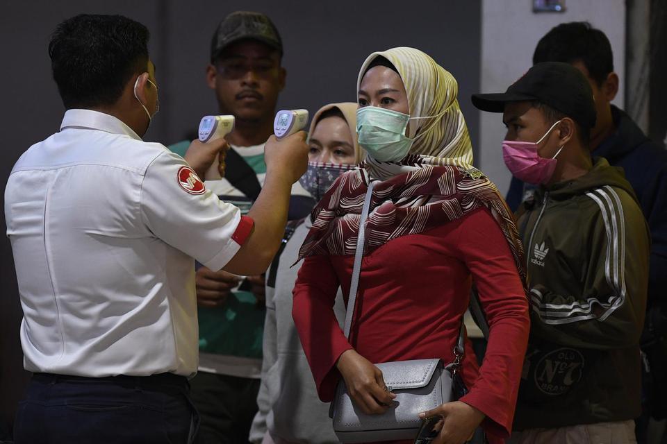 Petugas memeriksa suhu tubuh calon penumpang KRL Commuter Line di Stasiun Tanah Abang, Jakarta, Selasa (17/3/2020). PT Kereta Commuter Indonesia (KCI) memberlakukan kebijakan pengecekan suhu tubuh bagi penumpang KRL untuk mengantisipasi penyebaran virus c