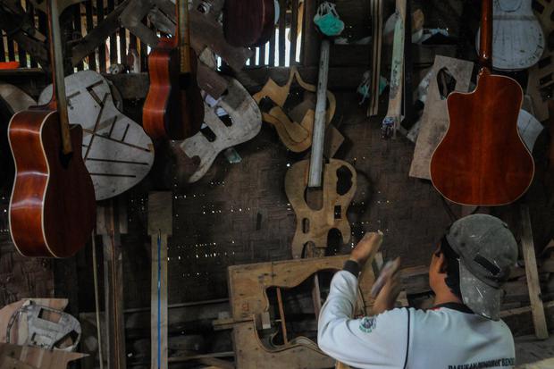 Pekerja memproduksi gitar di Workshop Guitars Gore di Lebak, Banten, Selasa (17/2/2020). OJK memberikan kelonggaran pembayaran pokok pinjaman serta bunga bagi pengusaha sektor usaha mikro kecil dan menengah (UMKM) kepada perbankan guna menyikapi dampak ne