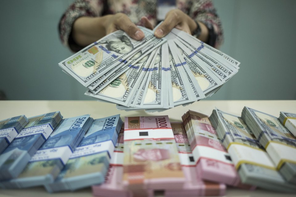Petugas menunjukkan uang rupiah dan dolar AS di Kantor Cabang Plaza Mandiri, Jakarta, Rabu (18/3/2020). Berdasarkan kurs referensi Jakarta Interbank Spot Dollar Rate (JISDOR) pada Rabu (18/3) hingga pukul 10.09 WIB, nilai tukar rupiah melemah 140 poin ata
