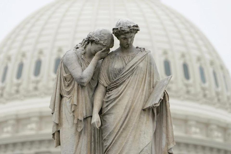 Kevin Lamarque "Kesedihan meletakkan wajahnya yang tertutup di bahu Sejarah dan menangis dalam duka" seperti yang terlihat di Monumen Perdamaian di depan gedung Capitol di Washington, Amerika Serikat, Senin (23/3/2020). Senat Amerika gagal mencapai kes