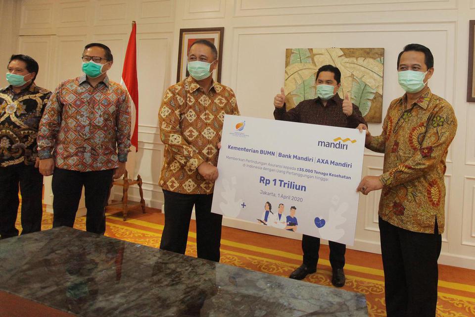 Dirut Bank Mandiri Royke Tumilaar (ketiga kiri) menyerahkan simbolis bantuan perlindungan asuransi bagi tenaga medis yang diterima Ketua Umum Ikatan Dokter Indonesia (IDI) Dr.