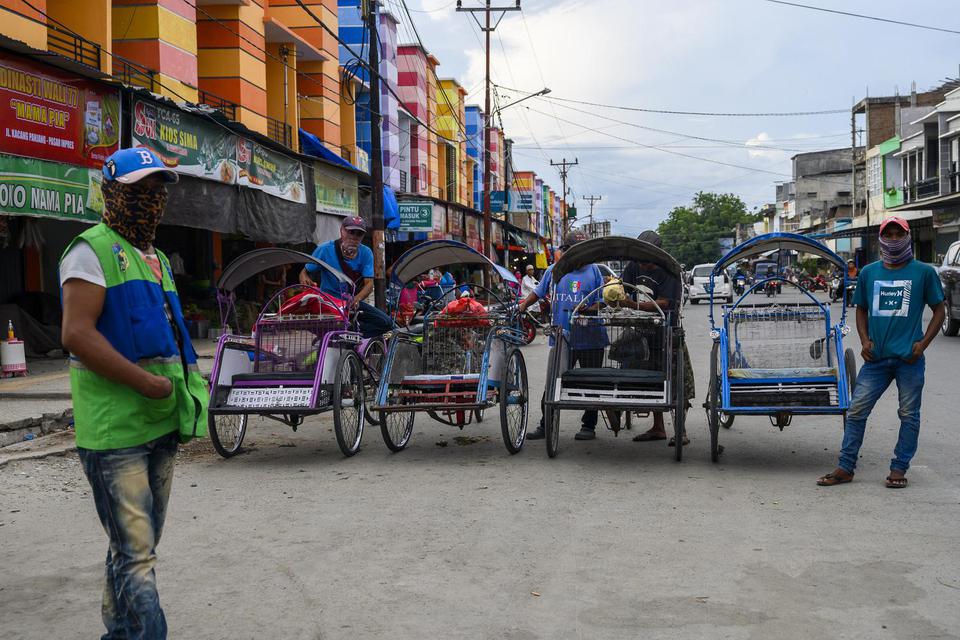 Sejumlah tukang becak menunggu penumpang di salah satu ruas jalan di Palu, Sulawesi Tengah, Minggu (5/4/2020). Pemerintah akan memberikan bantuan sosial kepada 29,3 juta penerima bantuan langsung tunai (BLT) yang tergolong dalam 40 persen warga miskin, te