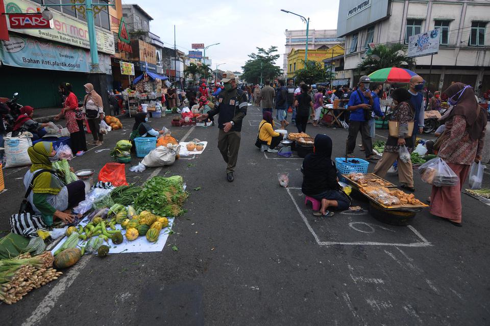 Anggota Satuan Polisi Pamong Praja Kota Salatiga memberi pengumuman waktu pasar pagi akan habis kepada pedagang di Pasar Pagi Salatiga, Jawa Tengah, Rabu (29/4/2020). Pemerintah Kota Salatiga menata para pedagang pasar pagi tersebut dengan menerapkan "ph