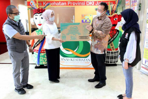 General Manager PT Uni-Charm Indonesia Tbk. Takeyuki Matsuura menyerahkan paket bantuan kepada Kepala Bidang Sumber Daya Kesehatan Dinkes Provinsi DKI