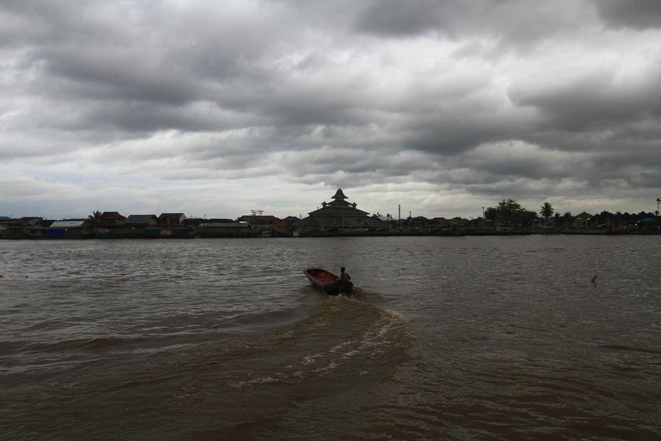 Seorang warga menyusuri Sungai Kapuas yang diselimuti awan gelap di Pontianak, Kalimantan Barat, Sabtu (2/5/2020). Kepala Stasiun Klimatologi Mempawah Kalimantan Barat Syafrinal menyatakan bahwa pada 1-10 Mei 2020 secara umum curah hujan di wilayah Kalbar