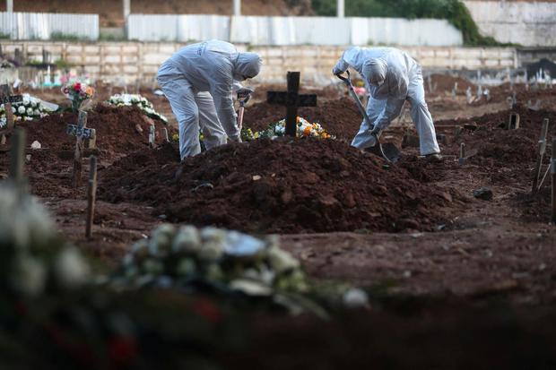 Penggali kubur memakai pakaian pelindung di sebuah pemakaman di Rio de Janeiro, Brazil, Jumat (8/5/2020).