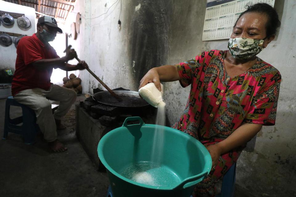 Perajin menuangkan gula pasir ke dalam baskom sebagai bahan baku pembuatan madumongso di Mojo, Kediri, Jawa Timur, Senin (11/5/2020). 