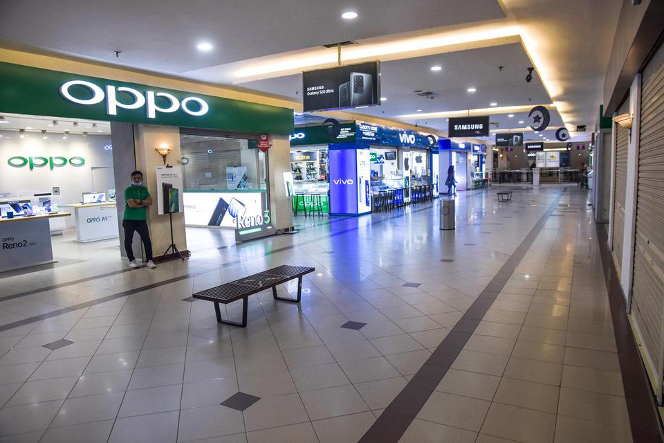 Sejumlah pekerja marketing menanti pembeli di toko gawai atau smartphone di pusat perbelanjaan yang sepi di Kota Pekanbaru, Riau, Selasa (12/5/2020).