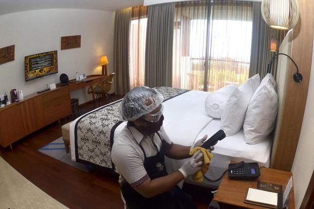 Pekerja hotel menggunakan alat pelindung diri saat menyiapkan kamar di Hotel Inaya Putri Bali, Nusa Dua, Badung, Bali, Jumat (5/6/2020). Menjelang penerapan tatanan hidup normal baru (new normal), hotel tersebut menerapkan protokol kesehatan seperti denga