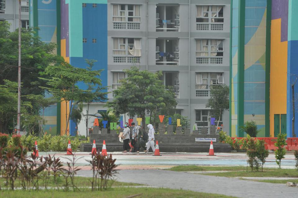 Petugas melintasi salah satu gedung wisma atlet Palembang, Sumsel, Senin (8/6/2020). Seiring dengan meningkatnya permintaan isolasi, Pemerintah Provinsi Sumsel berencana untuk menambah tiga tower wisma atlet untuk memenuhi kebutuhan tersebut.