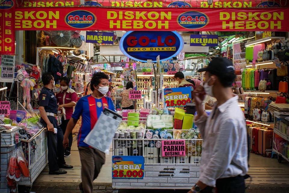 Pengunjung melintasi salah satu toko di Pasar Baru, Jakarta, Senin (8/6/2020). Dalam masa transisi, pasar tradisional mulai dibuka dengan menerapkan protokol kesehatan.