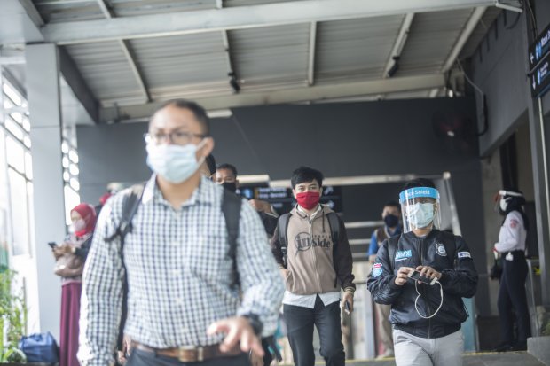 Sejumlah pekerja menggunakan pelindung wajah berjalan keluar dari Stasiun KRL Sudirman, Jakarta Pusat, Senin (8/6/2020). BPOM dan Kemenaker memberikan panduan berangkat, saat tiba di kantor, dan pulang kerja bagi para pekerja selama PSBB transisi Jakarta