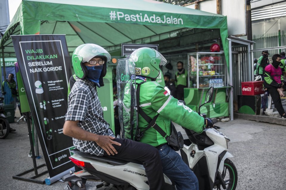 Pengemudi ojek online menggunakan pembatas mengangkut penumpang di Shalter Kawasan Stasiun Sudirman, Jakarta Pusat, Senin (8/6/2020). Pemerintah telah memperbolehkan ojek online mengangkut penumpang per tangga 8 Juni 2020 pada masa Transisi Fase I.