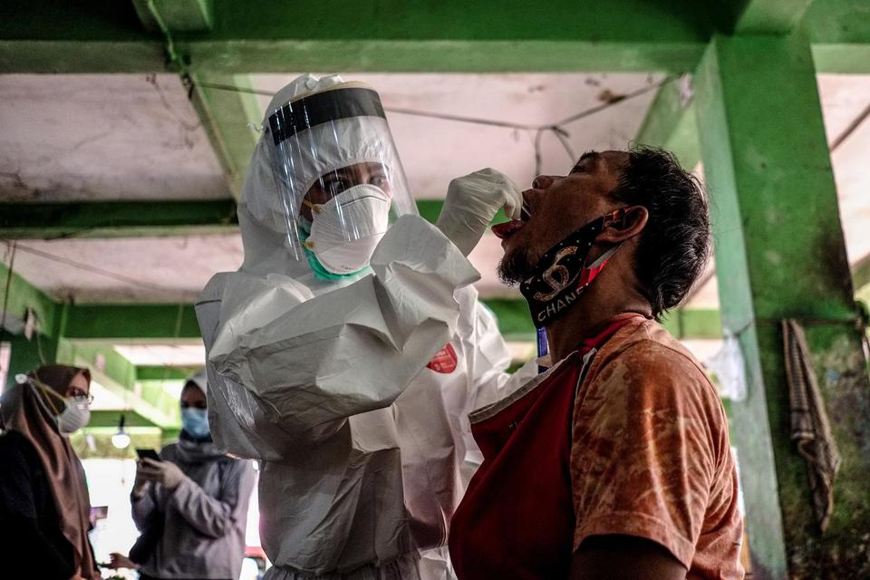 Petugas mengambil sampel cairan dari hidung dan tenggorokan pedagang saat mengikuti swab test di Pasar Pagi, Kota Pangkalpinang, Kepulauan Bangka Belitung, Kamis (11/6/2020). 