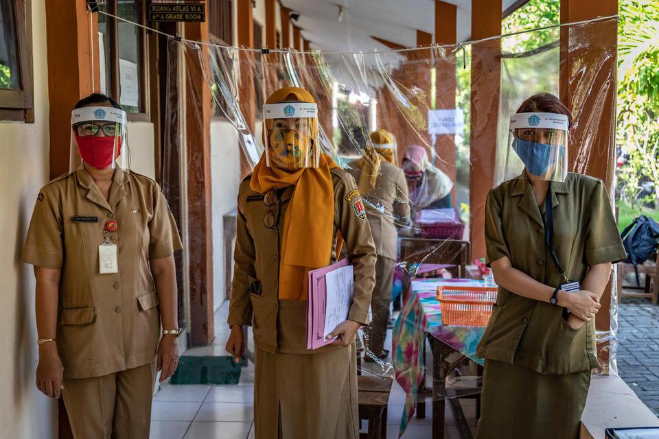 Panitia Penerimaan Peserta Didik Baru (PPDB) Tahun Pelajaran 2020/2021 mengenakan masker dan pelindung wajah di SDN Karangayu 02, Kelurahan Karangayu, Kota Semarang, Jawa Tengah, Senin (15/6/2020). tahun ajaran baru akan dimulai pada 13 Juli 2020.