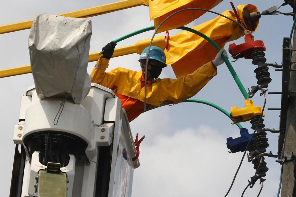 Pekerja memperbaiki jaringan listrik untuk rumah tangga di kawasan pemukiman padat penduduk di Jodipan, Malang, Jawa Timur, Rabu (17/6/2020). 