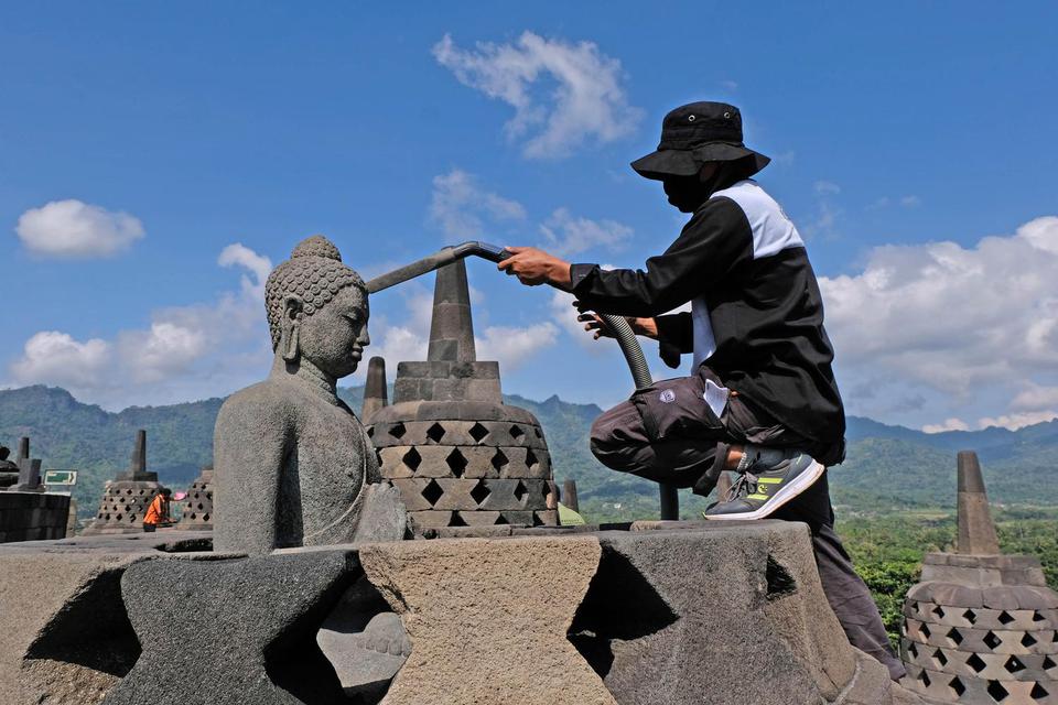 Petugas Balai Konservasi Borobudur (BKB) menyedot debu saat membersihkan abu vulkanik erupsi gunung Merapi di Candi Borobudur, Magelang, Jawa Tengah, Senin(22/6/2020). Pembersihan abu vulkanik erupsi gunung Merapi yang terjadi pada Minggu (21/6/2020) untu