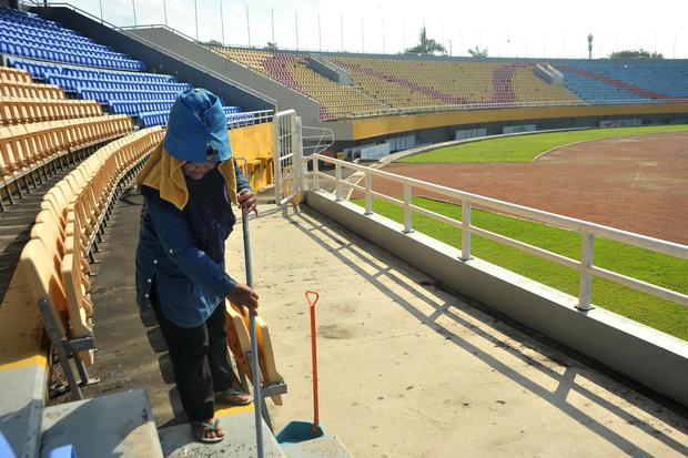 Petugas melakukan perawatan rutin di tribun Stadion Gelora Sriwijaya Jakabaring Palembang, Sumatera Selatan, Minggu (28/6/2020). Stadion Gelora Sriwijaya Jakabaring Palembang menjadi salah satu dari enam stadion yang ditunjuk Persatuan Sepak Bola Seluruh 