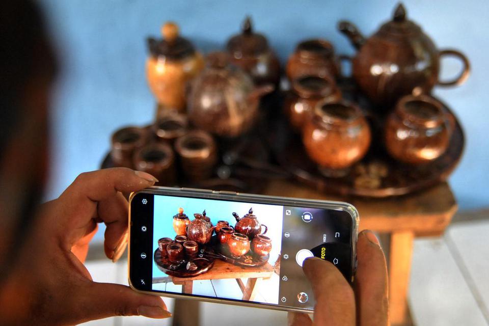 Ilustrasi, pekerja UMKM memotret kerajinan dari bahan limbah batok kelapa yang dipasarkan secara daring. Menteri Koordinator Bidang Perekonomian Airlangga Hartarto minta UMKM gencar manfaatkan kanal digital.