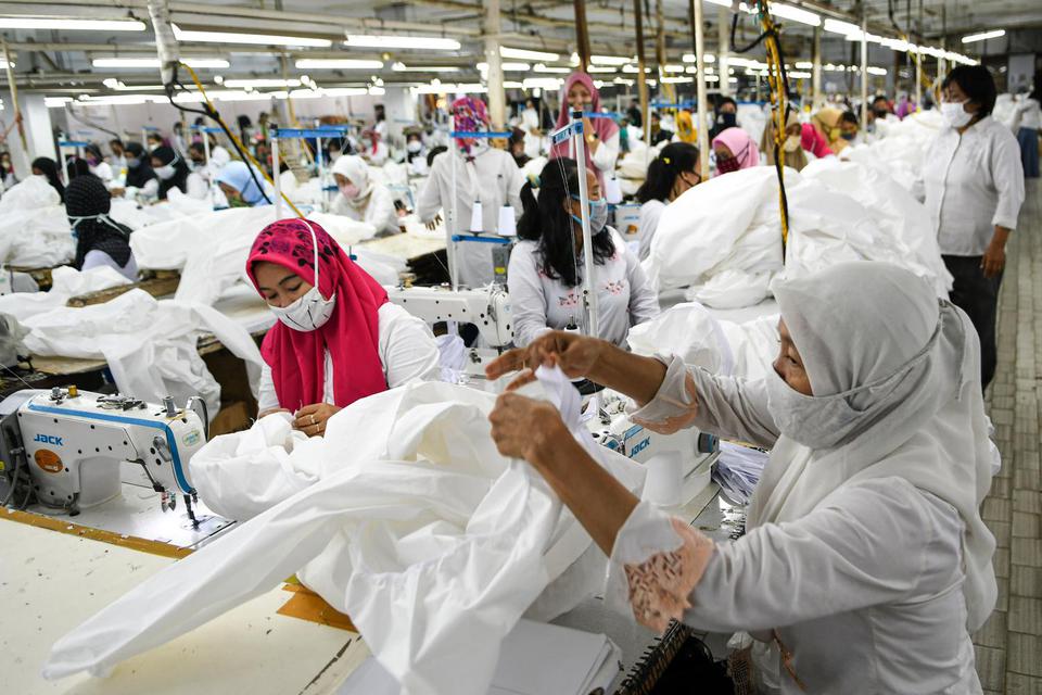 Pekerja perempuan memproduksi alat pelindung diri sebuah perusahaan garmen saat kunjungan Menteri Ketenagakerjaan Ida Fauziyah di Jakarta, Rabu (1/7/2020). 