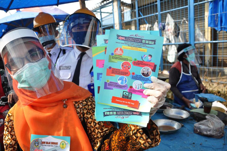 Petugas melakukan sosialisasi penerapan normal baru di pasar Bengkok Aksara Baru Medan, Sumatera Utara, Kamis (2/7/2020). 