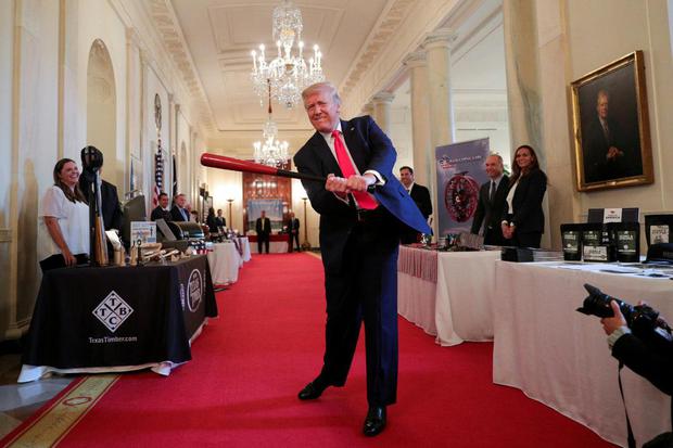 Tom Brenner Presiden Amerika Serikat Donald Trump mengayunkan tongkat bisbol kayu saat ia menghadiri acara "Spirit of America Showcase" di Cross Hall Gedung Putih di Washington, Amerika Serikat, Kamis (2/7/2020).