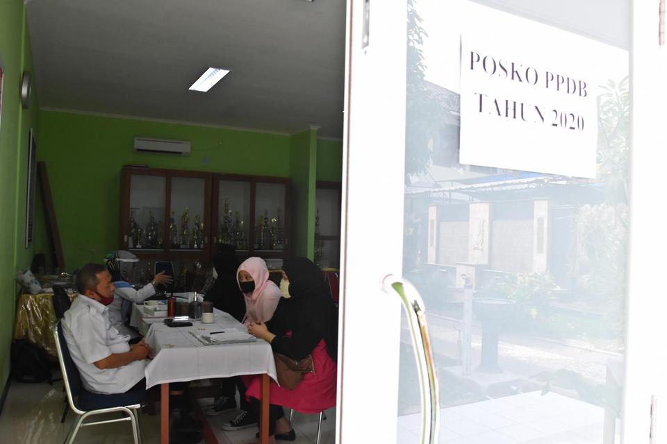 Calon peserta didik ditemani orang tuanya melaporkan diri dan verifikasi data pada jalur tahap akhir Penerimaan Peserta Didik Baru (PPDB) di Posko PPDB Suku Dinas Pendidikan Wilayah II Jakarta Selatan di Bulungan, Jakarta, Rabu (8/7/2020). Pendaftaran jal