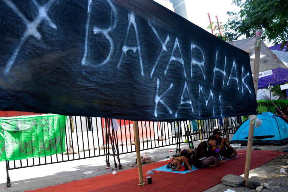 Sejumlah korban Pemutusan Hubungan Kerja (PHK) mendirikan tenda dan bermalam sebagai bentuk protes di depan kantornya, Makassar, Sulawesi Selatan, Kamis (9/7/2020). 