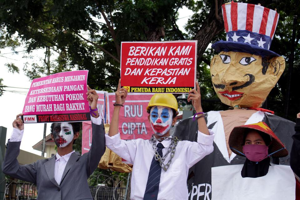 Demonstran membawa poster saat melakukan aksi unjuk rasa di depan Kantor DPRD Sulsel di Makassar, Sulawesi Selatan, Kamis (16/7/2020). Mereka menuntut DPR membatalkan Rancangan Undang-Undang (RUU) Omnibus Law Cipta Kerja serta mendesak pemerintah untuk me