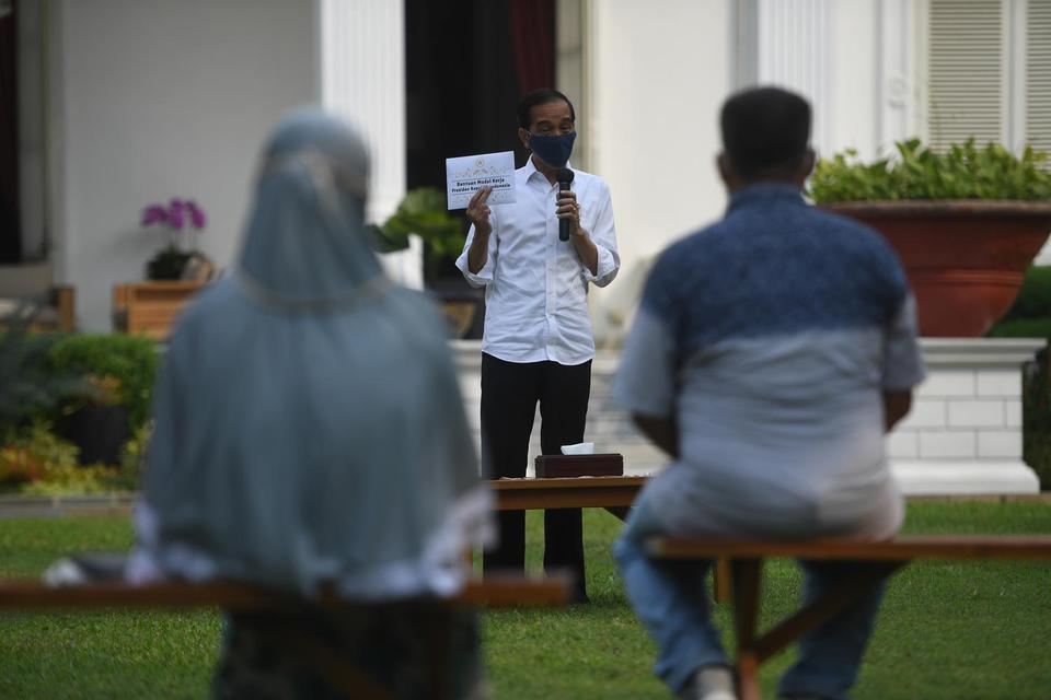 Presiden Joko Widodo (tengah) berpidato di sela acara pemberian bantuan modal kerja kepada pedagang kecil yang terdampak COVID-19 di halaman tengah Istana Merdeka, Jakarta, Selasa (21/7/2020). Presiden memberikan bantuan sebesar Rp2,4 juta kepada masing-m