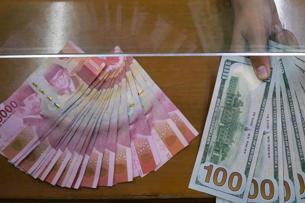 Petugas menunjukkan uang pecahan rupiah dan dolar AS (USD) di tempat penukaran uang Dolarindo, Melawai, Jakarta, Rabu (22/7/2020). Pada perdagangan hari ini, Rabu (22/7/2020) nilai tukar rupiah terhadap dolar AS ditutup menguat 91 poin dilevel Rp14.650 pe