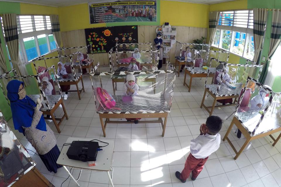 Sejumlah murid mengikuti kegiatan belajar secara tatap muka menggunakan meja bersekat plastik, di Sekolah Dasar Negeri (SDN) 09 Pasar Pandan Airmati (PPA), Kec. Tanjung Harapan, Kota Solok, Sumatera Barat, Jumat (24/7/2020). Sekolah tersebut memberlakukan