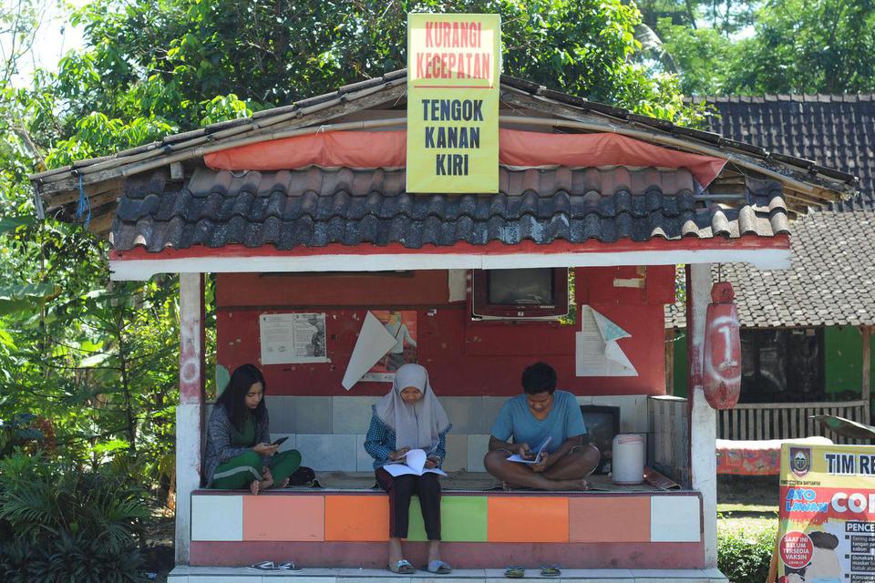 Sejumlah anak mengerjakan tugas pelajaran dari sekolah mereka dengan memanfaatkan fasilitas internet desa di Desa Banyuanyar, Ampel, Boyolali, Jawa Tengah, Senin (27/7/2020). 
