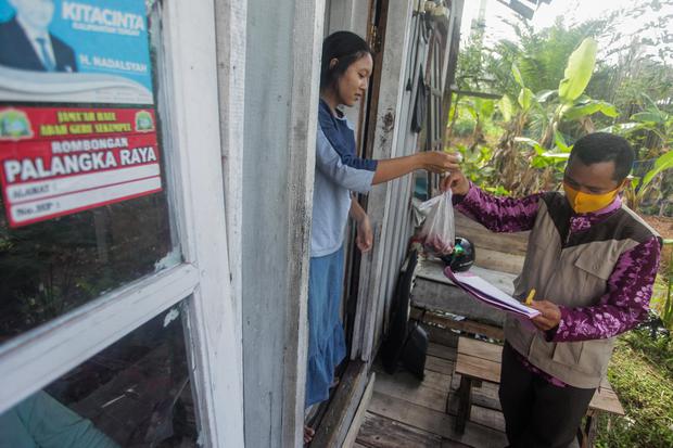 Panitia kurban menyalurkan daging kurban dengan mengantar ke rumah warga di Jalan George Obos, Palangkaraya, Kalimantan Tengah, Sabtu (1/8/2020). Penyaluran daging kurban dengan cara mendatangi langsung ke rumah-rumah warga dipilih panitia tersebut sebaga