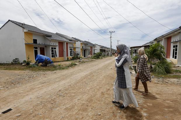 Warga melintas di depan rumah komplek KPR bersubsidi di Desa Lam Ujong Kecamatan Baitussalam, Aceh Besar, Aceh, Senin (3/8/2020). Kementerian Pekerjaan Umum dan Perumahan Rakyat (PUPR) telah mengalokasi anggaran Rp.11 triliun untuk membangun 102.500 unit 