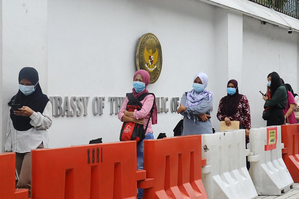 Sejumlah WNI memakai masker antre untuk masuk ke dalam di Kedutaan Besar Republik Indonesia, di Kuala Lumpur, Malaysia, Senin (3/8/2020). Pemerintah Malaysia mengumumkan mulai 1 Agustus masker wajib dipakai di dalam semua transportasi pengangkutan umum,