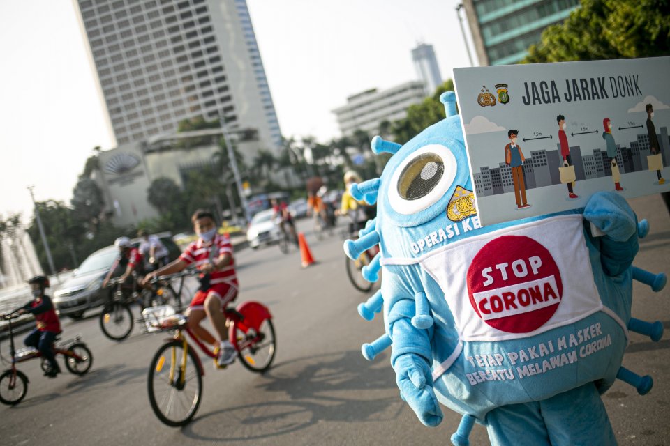 Petugas melakukan sosialisasi protokol kesehatan di tengah pandemi COVID-19 menggunakan poster di kawasan Bundaran HI, Jakarta, Minggu (13/9/2020). Sosialisasi tersebut dilakukan menjelang Pembatasan Sosial Berskala Besar (PSBB) total di Jakarta pada Seni