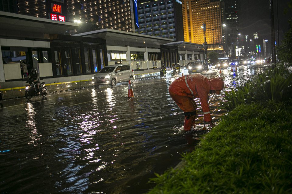 Petugas membersihkan saluran air di Kawasan Jalan Sudirman-Thamrin, Jakarta Pusat, Senin (21/9/2020). Hujan deras yang mengguyur sebagian wilayah ibu kota menyebabkan beberapa titik di Jakarta tergenang banjir hingga 50 centimeter.